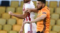 Pemain Olympiakos, Giorgos Masouras menyundul bola saat berduel dengan bek Wolverhampton Wanderers, Matt Doherty pada leg kedua babak 16 besar Liga Europa di Molineux Stadium, Kamis (6/8/2020). Wolverhampton menumbangkan Olympiakos dengan skor 1-0. (AP Photo/Rui Vieira)