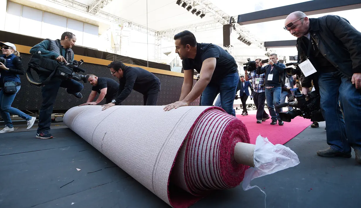 Petugas memasang karpet merah Academy Awards ke-90 di Dolby Theatre, California, Rabu (28/2). Ajang Oscar 2018 digelar pada 4 Maret, di mana para bintang Hollywood berkumpul menghadiri acara tahunan yang bergengsi. (Kevork Djansezian/Getty Images/AFP)