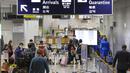Penumpang menunggu dalam antrean untuk menerima tes karantina pada saat kedatangan mereka di Bandara Internasional Kansai, Osaka, Jepang, Selasa (30/11/2021). Infeksi COVID-19 varian Omicron di Jepang didapatkan secara impor. (Yukie Nishizawa/Kyodo News via AP)
