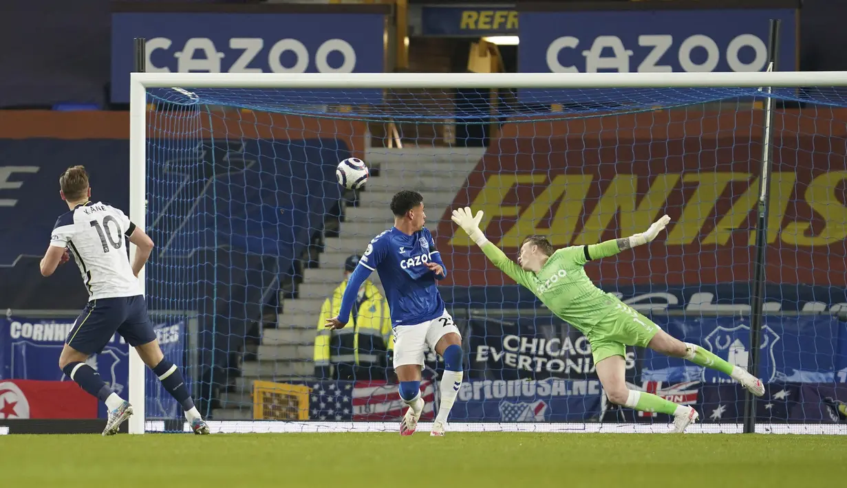 Striker Tottenham Hotspur, Harry Kane (kiri) mencetak gol keduanya ke gawang Everton yang dikawal Jordan Pickford dalam laga lanjutan Liga Inggris 2020/2021 pekan ke-32 di Goodison park, Liverpool, Jumat (16/4/2021). Tottenham bermain imbang 2-2 dengan Everton. (AP/Jon Super/Pool)