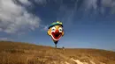 Balon udara berkarakter badut bersiap mengudara saat Festival Balon Udara Gilboa di dekat Kibbutz Ein Harod, Lembah Jizreel, Israel (4/8). (AFP Photo/Manahem Kahana)