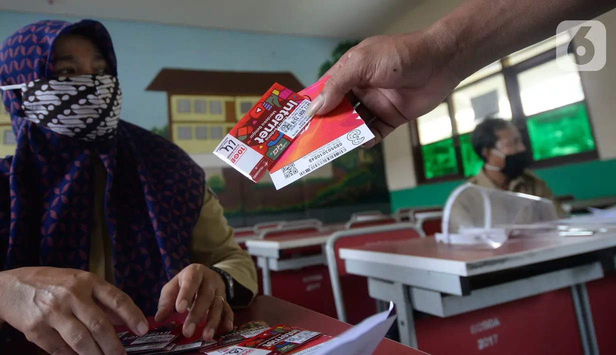 Wali murid menerima dua kartu perdana Tri dan Telkomsel beserta kuota gratis di SDN Serua Indah I dan II, Ciputat, Tangerang Selatan, Senin (15/9/2020). Program Kartu Perdana tersebut untuk mendukung kegiatan belajar secara online di masa pandemi covid-19. (merdeka.com/Dwi Narwoko)