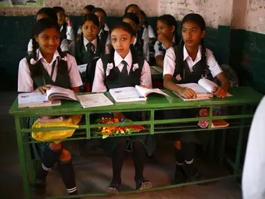 Mantan Dewi Nepal atau Kumari, Matina Shakya (tengah) duduk di kelas pada hari pertama sekolahnya di Kathmandu (9/10). Setelah pubertas Matina Shakya harus pensiun menjadi sosok dewi hidup yang disembah banyak orang di Nepal. (AFP Photo/Gopen Rai)