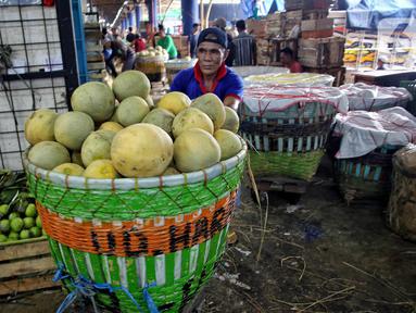 Pedagang mendorong gerobak berisi buah segar yang akan di jual di pasar Kramat Jati, Jakarta, Kamis (13/3/2025). (Liputan6.com/Angga Yuniar)