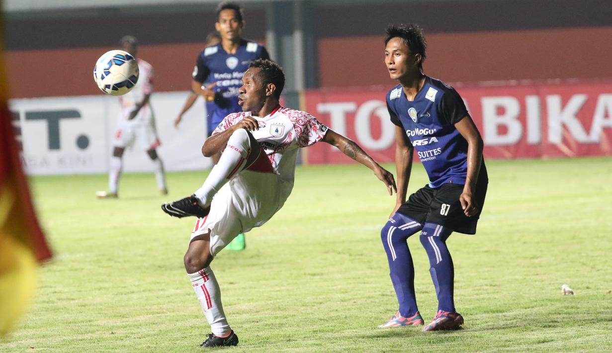 Pemain Persipura Jayapura, Ferinando Pahabol (kiri) berebut bola dengan pemain Arema Cronus pada laga grup E Piala Jenderal Sudirman di Stadion Maguwoharjo, Sleman, Minggu (13/12/2015) (Bola.com/Nicklas Hanoatubun) 