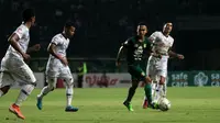 Pemain Persebaya, Abu Rizal (hijau), dikepung pemain Tira Persikabo di Stadion Gelora Bung Tomo, Surabaya, Minggu (21/7/2019). (Bola.com/Aditya Wany)