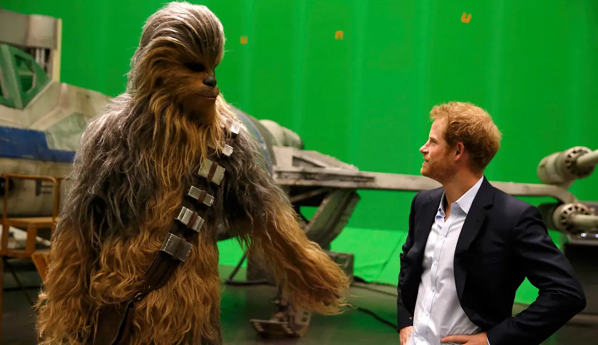 Pangeran Harry bertemu Chewbacca saat berkunjung ke studio pembuatan film Star Wars di Pinewood Studios, London, Selasa (19/4). Pangeran William dan Harry berkeliling Pinewood untuk mengunjungi workshop produksi film Star Wars (REUTERS/Adrian Dennis/Pool)