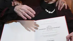 Seorang wanita mengucapkan selamat kepada Ingeborg Rapoport (102 tahun) saat ia berpose menunjukkan sertifikat doktornya yang baru dia terima, di rumah sakit UKE di Hamburg, Jerman, Selasa (9/6/2015). (REUTERS/Fabian Bimmer)