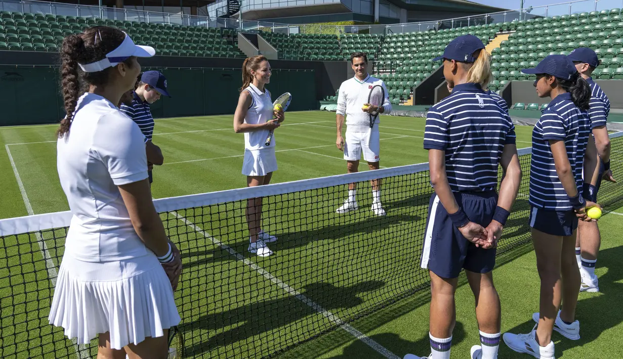 Kate Middleton, petenis juara delapan kali turnamen Wimbledon Roger Federer dan sejumlah penangkap bola berbincang tentang keterampilan yang dipelajari selama pelatihan sebagai penangkap bola.  (Thomas LOVELOCK / AELTC / AFP)