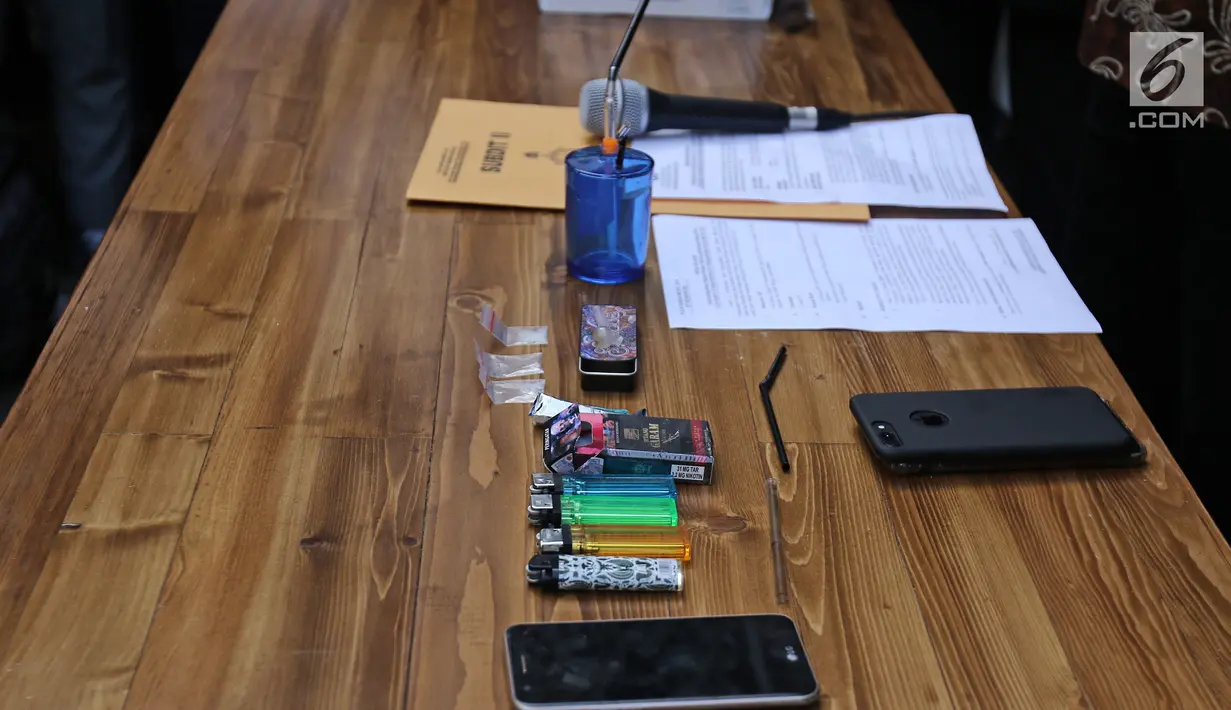 Barang bukti berupa telepon genggam, korek api, bong dan sabu yang berhasil disita polisi di Dit Narkoba Polda Metro Jaya, Jakarta, Jumat (22/12). Polisi menangkap Tio Pakusadewo pada 19 Desember 2017. (Liputan6.com/Herman Zakharia)