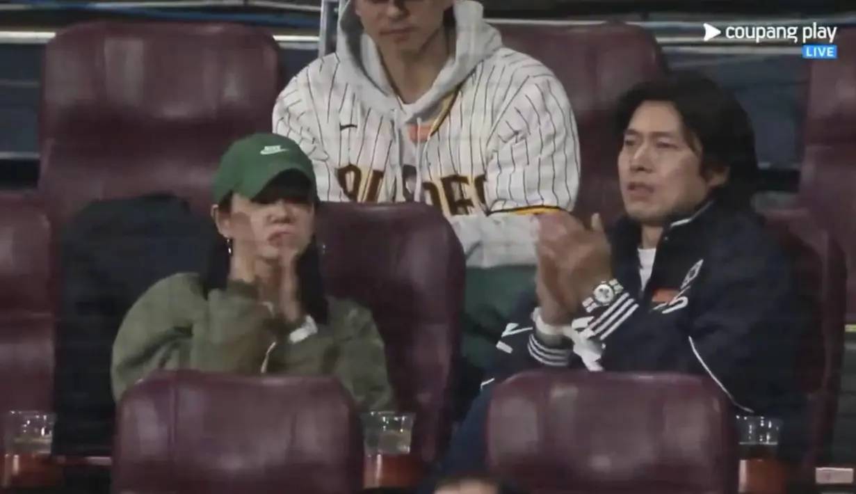 Awalnya, kamera hanya menyorot pasangan selebritas Hyun Bin dan Son Ye Jin. Mereka kompak bertepuk tangan di tengah pertandingan. (Foto: Coupang Play)
