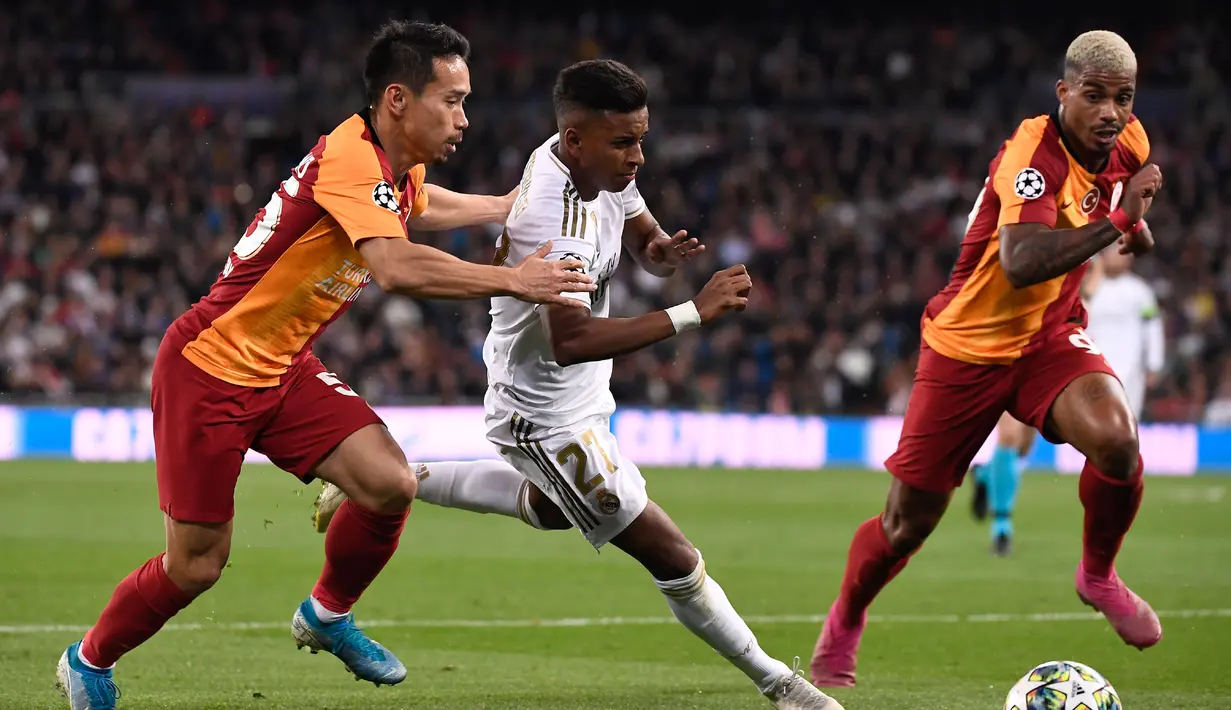Pemain Real Madrid Rodrygo (tengah) melewati pemain Galatasaray Yuto Nagatomo (kiri) dan Mario Lemina (kanan) pada pertandingan Grup A Liga Champions di Stadion Santiago Bernabeu, Madrid, Spanyol, Rabu (6/11/2019). Rodrygo mencetak tiga gol ke gawang Galatasaray. (PIERRE-PHILIPPE MARCOU/AFP)