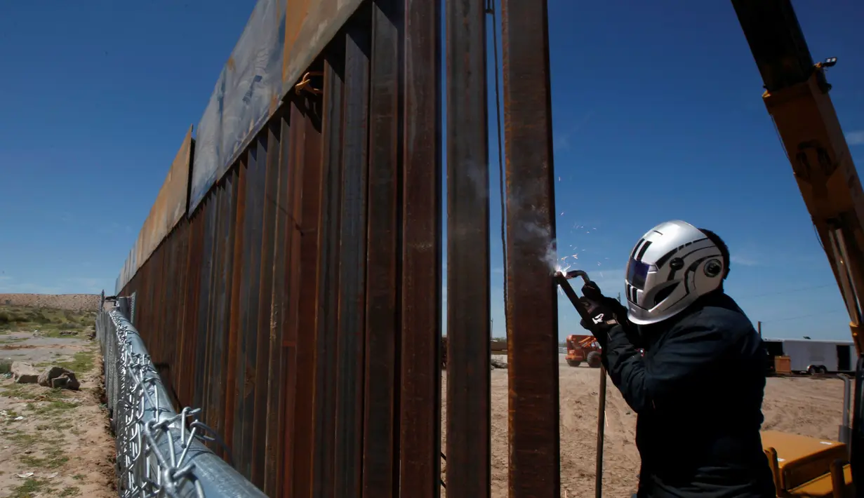 Seorang pekerja AS sedang mengelas bagian dari dinding perbatasan AS-Meksiko di Sunland Park, AS (09/9). AS dan Mexico dipisahkan oleh sekat teritorial yang menandakan wilayah kedaulatan masing-masing negara. (REUTERS/Jose Luis Gonzalez)