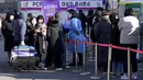 Seorang pekerja medis (tengah) memandu orang-orang saat menunggu tes virus corona di tempat pengujian darurat di Seoul, Rabu (23/2/2022). Kasus harian COVID-19 baru Korea Selatan mencapai rekor tertinggi, melonjak menjadi 171.452 dari 99.569 kasus sehari sebelumnya. (AP Photo/Ahn Young-joon)