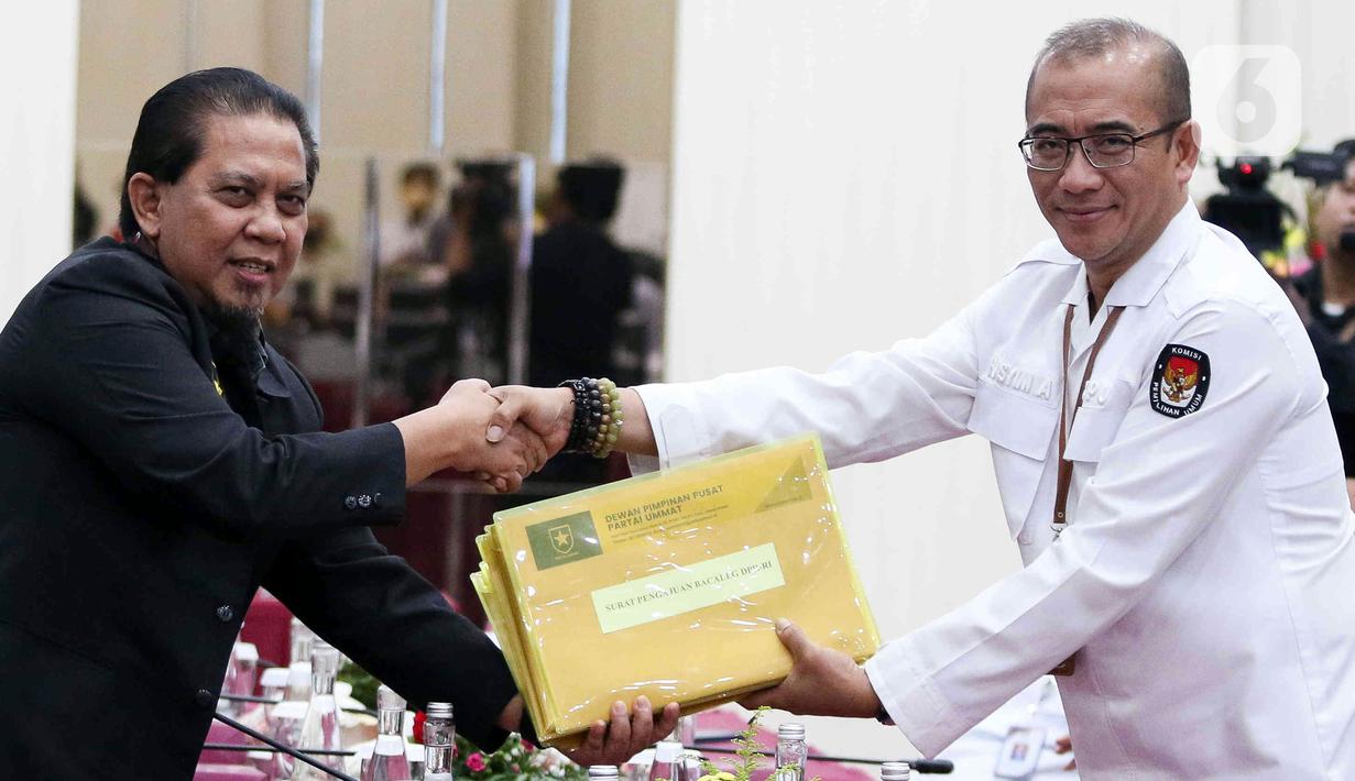Wakil Ketua Umum (Waketum) Partai Ummat Nazaruddin menyerahkan dokumen daftar bakal calon legislatif (bacaleg) kepada Ketua Komisi Pemilihan Umum (KPU) Hasyim Asy'ari di Gedung KPU, Jakarta, Kamis (11/5/2023). (Liputan6.com/Herman Zakharia)