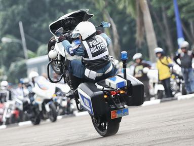 Petugas pasukan Polisi Militer TNI AL beratraksi mengendarai motor gede saat Hut Polisi Militer Angkatan Laut ke-70 di Mako Puspomal TNI AL, Jakarta, Jumat (19/2/2016). HUT Pomal setiap tahunnya diperingati pada 20 Februari. (Liputan6.com/Faizal Fanani)