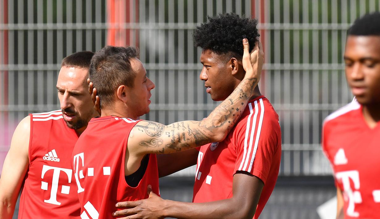 Gelandang Bayern Munchen, Rafinha, tampak berbincang santai dengan David Alaba saat latihan perdana di Munchen, Rabu (12/7/2017). (EPA/Lukas Barth)