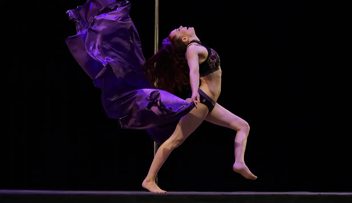 Aksi Elizabeth Tuazon menunjukkan gerakan tari tiang saat mengikuti Kompetisi Divison Profesional selama Kejuaraan Pole Dance (USPDF) AS 2019 di New York, 13 April 2019. Pole Dance merupakan seni pertunjukan gabungan tari dan akrobat yang menggunakan tiang. (TIMOTI A. CLARY / AFP)