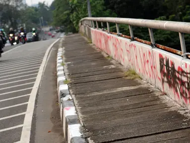 Pengendara melintasi jembatan layang Jalan HR Rasuna Said, Jakarta, Selasa (11/7). Dinding pembatas jembatan layang HR Rasuna Said arah kuningan dipenuhi coretan. (Liputan6.com/Helmi Fithriansyah)