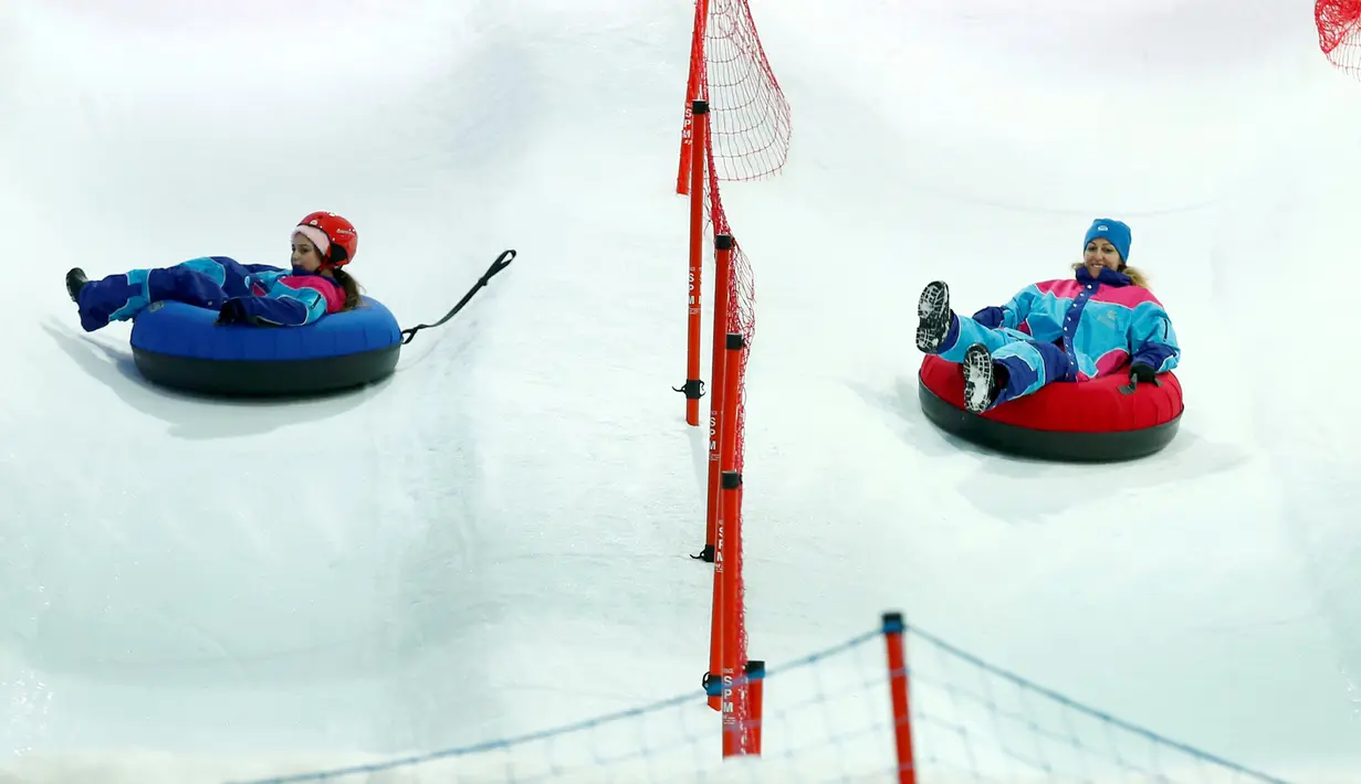 Pengunjung berseluncur di atas salju yang terdapat di wahana Snow City, Mall Al Othaim, Riyadh, Arab Saudi, (26/7). Warga Riyadh dapat menikmati asyiknya bermain di salju buatan. (REUTERS/Faisal Al Nasser)