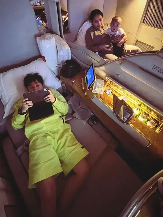 Di dalam pesawat, Rafathar tak bisa tidur. Ia pun memilih bermain gadget kesayangannya. (Foto: Instagram/@chevirgo)