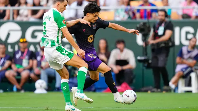 Pemain Barcelona Xavi Espart (kanan) berebut bola dengan pemain Real Betis Diego Llorente