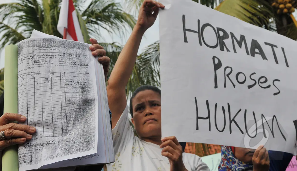 Warga perumahan Pati Polri membentangkan tulisan menolak penggusuran rumah mereka di Cipinang Baru Bunder, Jakarta, Selasa (26/5/2015). Sebanyak 6 rumah yang telah memiliki girik/bukti pembelian selama 48 tahun akan digusur. (Liputan6.com/Herman Zakharia)
