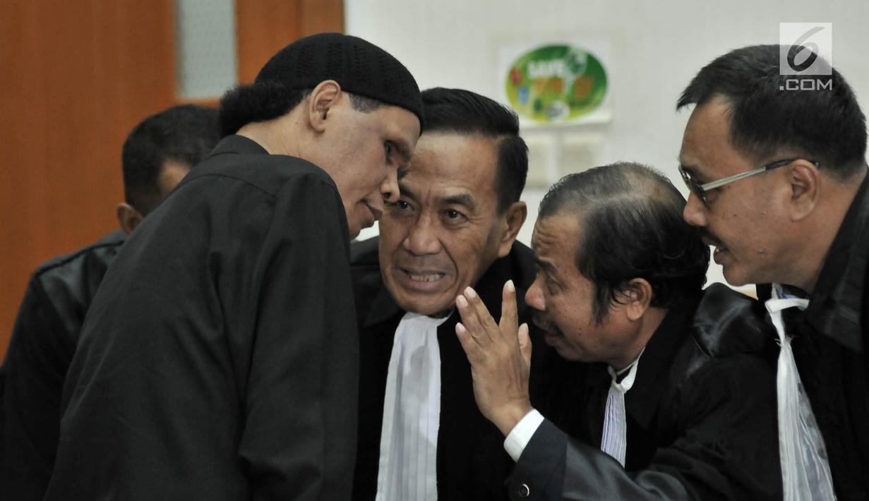Terdakwa Hercules Rosario Marshal berdiskusi dengan kuasa hukum saat sidang vonis terkait kasus penguasaan lahan milik PT Nila Alam di Pengadilan Negeri Jakarta Barat, Rabu (27/3). Majelis Hakim PN Barat memvonis Hercules 8 bulan penjara. (merdeka.com/Iqbal S. Nugroho)