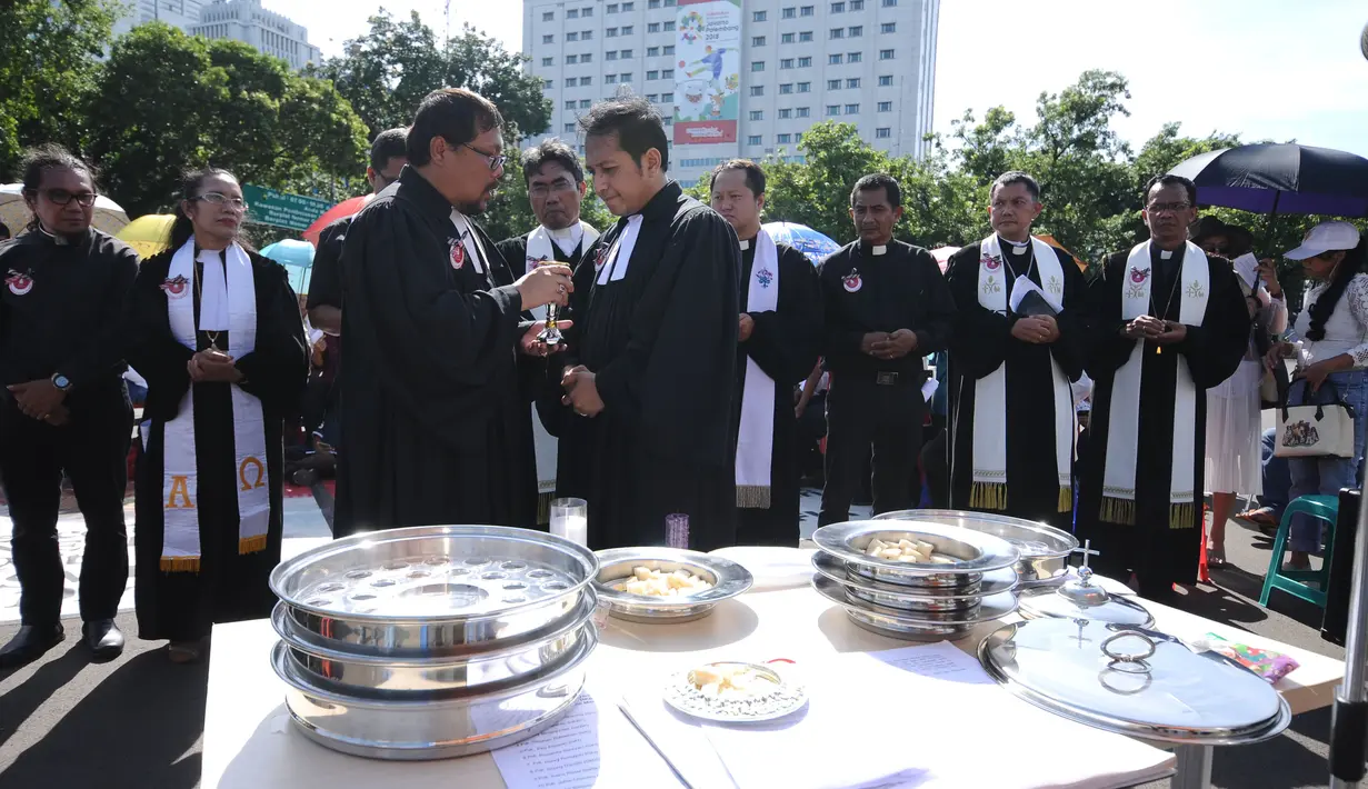 Pendeta usai memberi perjamuan pada jemaat GKI Yasmin dan HKBP Filadelfia pada misa Natal 2017 di Silang Barat Laut Monas, Jakarta, Senin (25/12). Dipimpin 16 pendeta dari beragam gereja, mereka menggelar kebaktian Natal. (Liputan6.com/Helmi Fithriansyah)