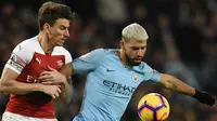 Striker Manchester City, Sergio Aguero (kanan) mencoba menahan bek Arsenal Laurent Koscielny saat bertanding pada Premier League di Stadion Etihad, Manchester, Inggris, Minggu (3/2). City menang 3-1 atas Arsenal. (OLI SCARFF/AFP)