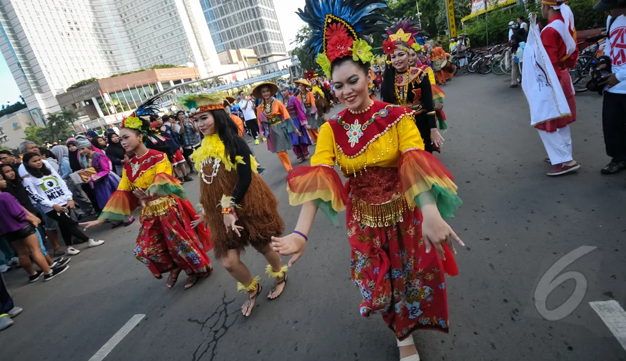 Aksi menari Mahasiswa Universitas Paramadina saat car free day di Bundara HI, Jakarta, Minggu (26/4/2015). Mereka meminta sumbangan kepada warga untuk mengikuti Interntional Folklore Festival di Spanyol. (Liputan6.com/Faizal Fanani)