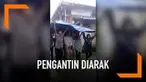 Hujan yang turun tak menghalangi pengantin ini untuk menjalani prosesi pernikahan. Keduanya diarak dan dipayungi warga menggunakan terpal plastik sampai ke tenda pelaminan.