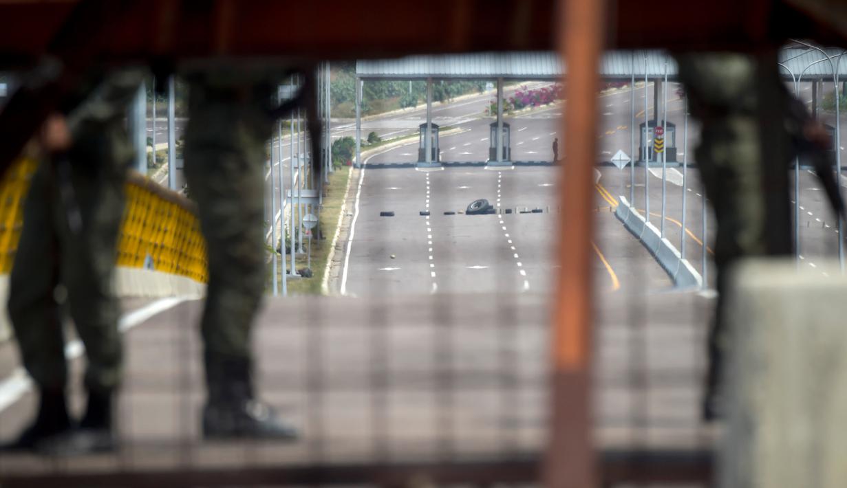 Pasukan militer Venezuela berjaga saat memblokir perbatasan dengan Kolombia di Jembatan Tienditas, Cucuta, Kolombia, Rabu (6/2). Diduga, pemblokiran bentuk kekhawatiran pemerintah berkuasa atas kemungkinan intervensi militer asing. (Raul Arboleda/AFP)