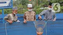 Santri mengambil ikan mujair nila merah di budidaya ikan Pesantren Ruhama Al Fajar, Citayam, Bogor, Jawa Barat, Selasa (29/6/2021). Tidak hanya dibekali Ilmu Agama, di pesantren ini santrinya dibekali suntuk menjadi entrepreneur dalam budidaya ikan nila merah. (merdeka.com/Arie Basuki)