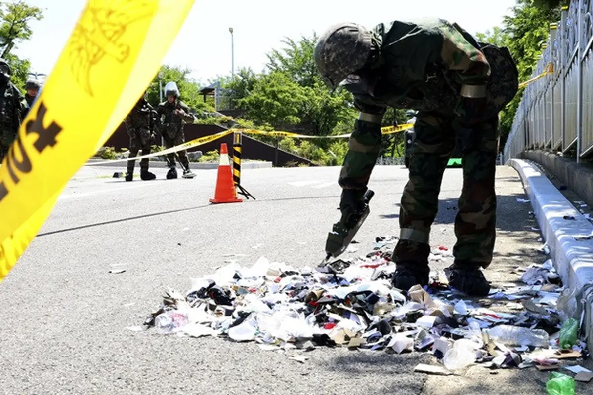 Tentara Korea Selatan yang mengenakan alat pelindung diri memeriksa sampah dari balon yang dikirim oleh Korea Utara di Incheon, Korea Selatan, Minggu (2/6/2024).