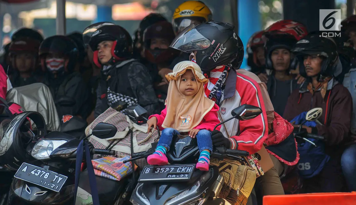Seorang anak duduk di atas motor saat menanti waktu masuk kapal penyebrangan di Dermaga 1 Pelabuhan Penyebrangan Merak, Banten, Sabtu (1/6/2019). Meski berbahaya, pemudik tetap nekat membawa anak berkendara sepeda motor menuju kampong halaman. (Liputan6.com/Helmi Fithriansyah)