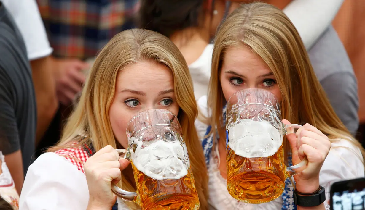 Dua gadis cantik menikmati bir saat menghadiri pembukaan Oktoberfest ke-183 di Munich, Jerman, Sabtu (17/9). Wanita-wanita cantik ini berpesta-pora dengan meminum bir selama pembukaan Oktoberfest. (REUTERS/Michaela Rehle)