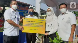 Direktur Utama Bank BTN Haru Koesmahargyo (kiri) disaksikan Wakil Menteri Keuangan Suahasil Nazara (kedua kanan) memberikan bantuan 1.000 bibit pohon peneduh untuk meningkatkan penghijauan di kawasan perumahan subsidi di Pekanbaru, Selasa (2/11/2021). (Liputan6.com/HO/BTN)