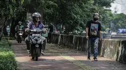 Sejumlah pengendara motor melintas di atas trotoar pejalan kaki di kawasaan Daan Mogot, Jakarta, Senin (26/4/2021). Padatnya volume kendaraan pada jam kerja di kawasan itu membuat sejumlah pengendara motor nekat menggunakan trotoar yang merupakan
hak bagi pejalan kaki. (Liputan6.com/Faizal Fanani)