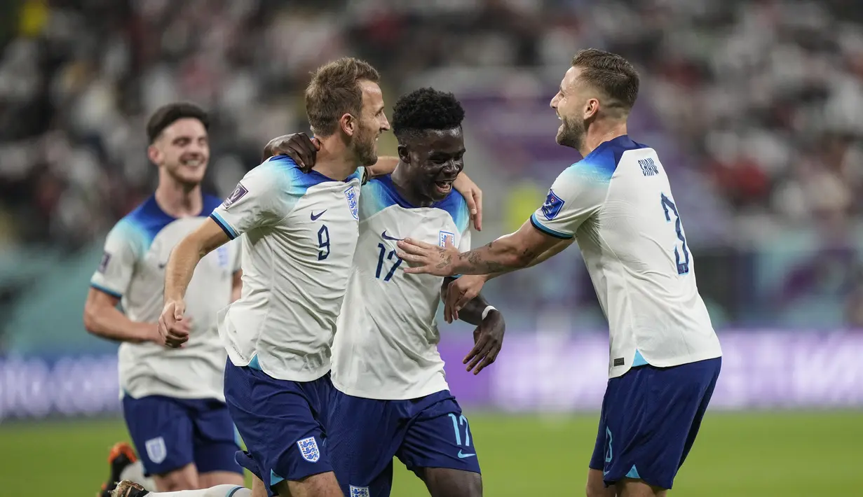 Gelandang Inggris, Bukayo Saka (kedua kanan) merayakan dengan rekan satu timnya setelah mencetak gol keempat timnya ke gawang Iran selama pertandingan grup B Piala Dunia 2022 Qatar di Stadion Internasional Khalifa di Doha, Qatar, Senin (21/11/2022). Dengan kemenangan ini, Inggris berada di puncak klasemen dengan tiga poin. (AP Photo/Martin Meissner)
