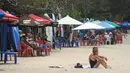 Sejumlah turis menikmati pantai Kuta di pulau pariwisata Indonesia di Bali (4/1). Pantai Kuta terkenal memiliki ombak yang bagus untuk olahraga selancar, terutama bagi peselancar pemula. (AFP Photo/Sony Tunbelaka)