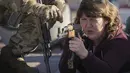 Seorang wanita memegang senjata selama pelatihan perang dasar untuk warga sipil oleh Unit Pasukan Khusus Azov, dari Garda Nasional Ukraina, di Mariupol, wilayah Donetsk, Minggu (13/2/2022). Mereka disiapkan untuk bisa bertahan di tengah kekhawatiran akan invasi Rusia. (AP Photo/Vadim Ghirda)