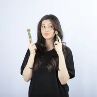 Seorang perempuan sedang memegang dua buah brush di tangannya (Foto Dok: Freepik/azerbaijan_stockers).