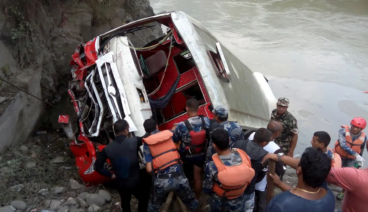 Tim penyelamat berkumpul di lokasi terceburnya bus sarat penumpang ke dalam sungai Trishuli di Distrik Dhading, Nepal, Sabtu (28/10). Bus nahas itu tergelincir dari jalan tol utama di ibu kota dan tercebur ke sungai. (HARIHAR SINGH RATHOR/AFP)