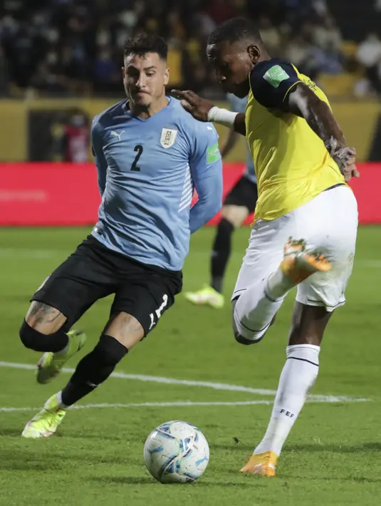 Bek Uruguay, Jose Maria Gimenez berebut bola dengan bek Ekuador, Pervis Estupinan pada lanjutan Kualifikasi Piala Dunia 2022 zona Amerika Selatan di Estadio Campeón del Siglo, Jumat (10/9/2021) pagi WIB. Uruguay menang tipis 1-0 lewat gol gasto Pereiro. (Raul MARTINEZ / AFP / POOL)