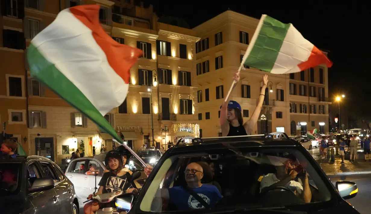 Suporter merayakan kemenangan Italia atas Inggris pada pertandingan final Euro 2020 di Roma, Italia, Senin (12/7/2021). Italia menjuarai Euro 2020 usai mengalahkan Inggris lewat drama adu penalti pada pertandingan final. (AP Photo/Gregorio Borgia)
