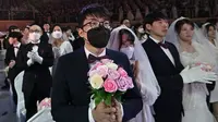 Peserta pernikahan massal di Korea Selatan terpaksa mengenakan masker guna mengantisipasi penyebaran Virus Corona. (Source: AFP)