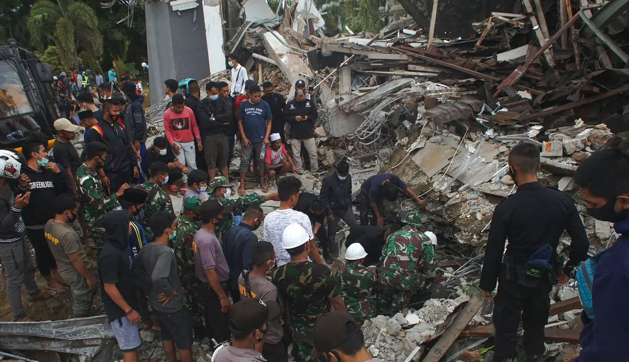 Tim penyelamat mencari korban di antara reruntuhan bangunan yang rusak akibat gempa bumi di Mamuju, Sulawesi Barat, Jumat (15/1/2021). Gempa ini menyebabkan kerusakan parah pada Hotel Maleo, kantor Gubernur Sulbar, serta RSUD Mamuju. (AP Photo/Azhari Surahman)