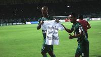 Pemain Persebaya merayaka selebrasi dengan membentangkan kaus putih tanda duka cita atas kematian salah satu Bonek Mania. (Bola.com/Aditya Wany)