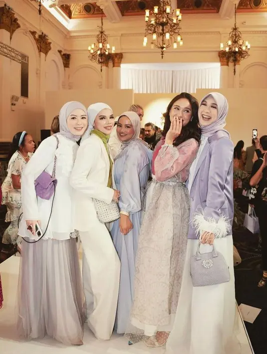 Yasmin mengenakan turtleneck top pink, dipadu outer organza, dan rok tulle panjang warna putih.